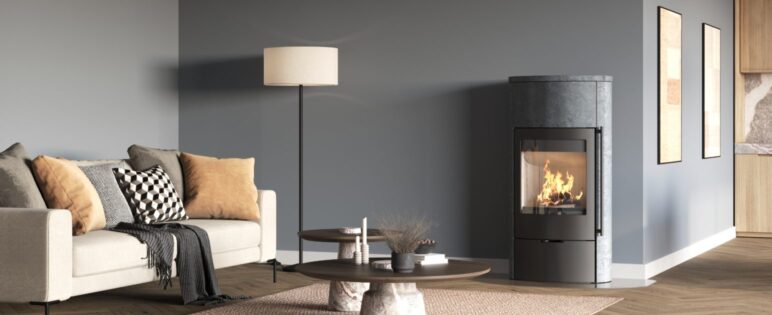 Modern täljstenskamin med brasa i ett ljust vardagsrum med soffa och soffbord